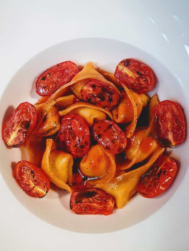 Ravioli rellenos de ricotta y parmesano con tomates asados