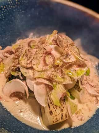 Espárragos asados con crema de champiñones, láminas frescas de champiñones y aceite de perejil