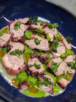 Pulpo a la brasa con reducción de su agua y emulsión de perejil