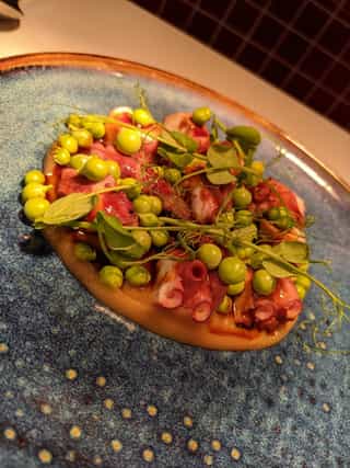 Pulpo en crema de cebolla dulce y guisantes