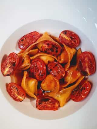 Ravioli rellenos de ricotta y parmesano con tomates asados